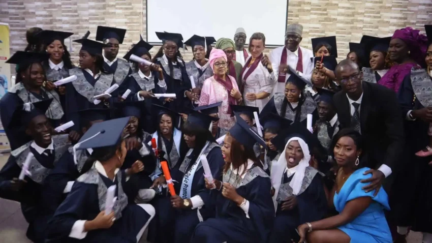 Étudiants en tenue de diplômé posant avec les responsables de l'établissement.