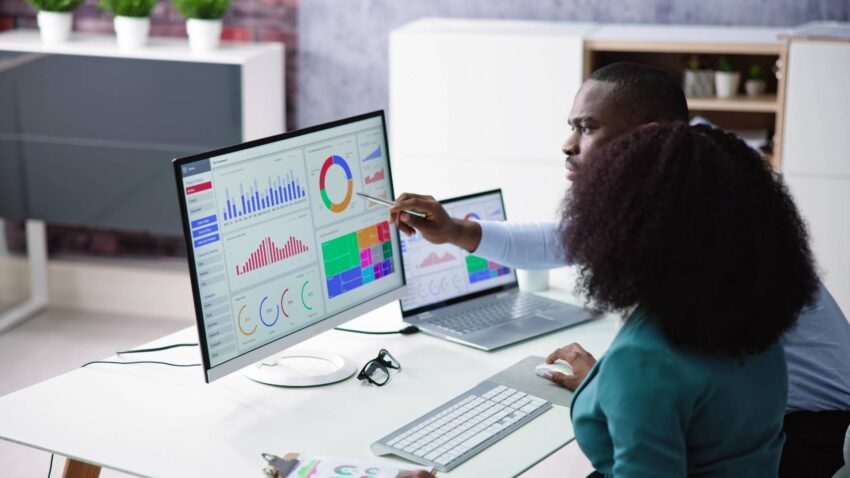 Deux personnes consultant un écran avec des graphiques