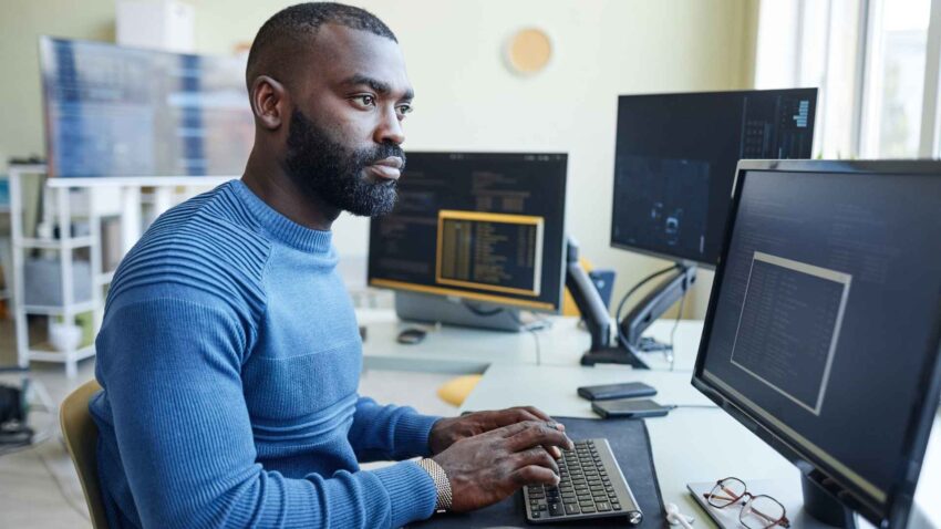 Un homme travaille sur son écran et tape au clavier