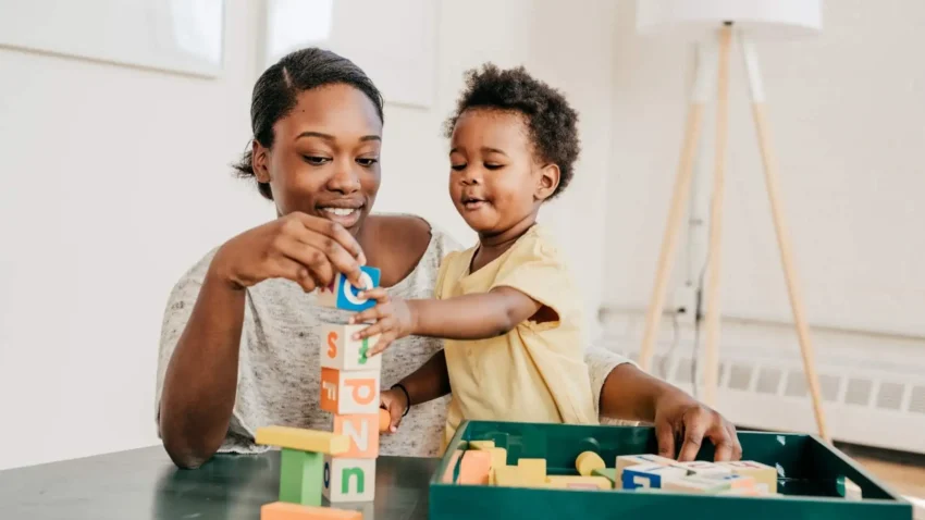 une dame tenant un enfant qui joue
