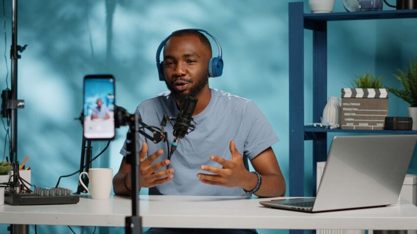 Un homme se filme avec son smartphone en parlant dans un micro