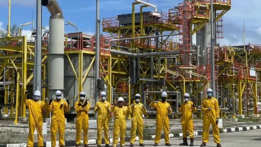 groupe de travailleurs réunis devant une installation industrielle