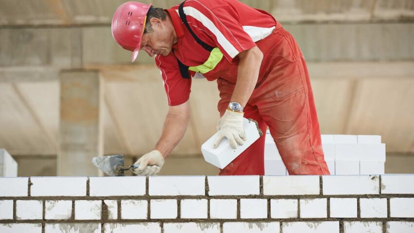 Maçon construisant un mur en briques